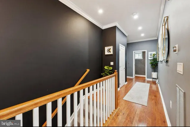 a view of a hallway with wooden floor and windows