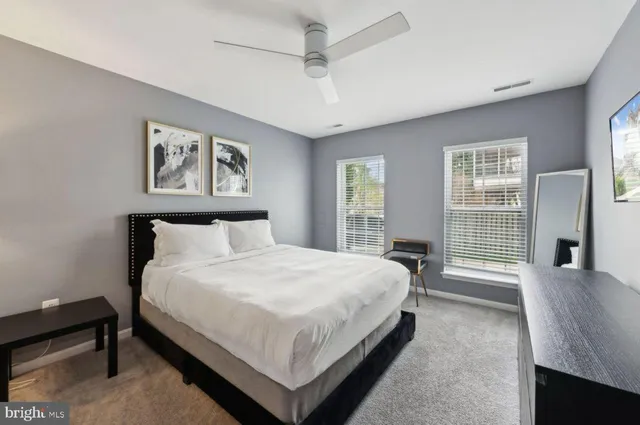 a large bed sitting in a bedroom next to a window and a chandelier