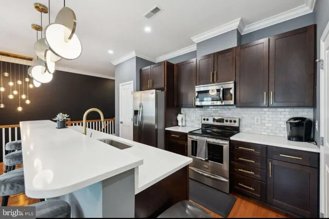 a kitchen with stainless steel appliances a stove refrigerator sink microwave and cabinets