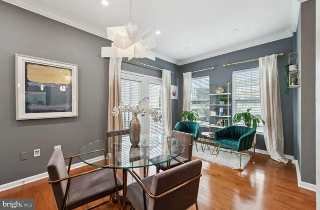 a living room with furniture a lamp wooden floor and a chandelier