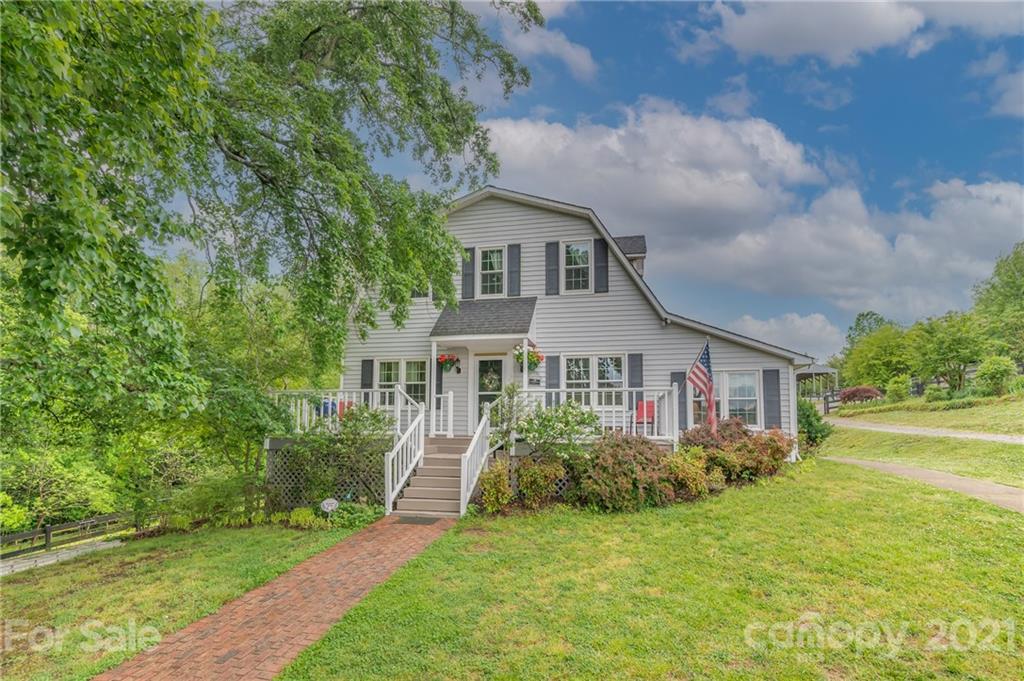 4733 Hunting Country Road Tryon, NC 28782 - Photo 1 of 48 a front view of a house with garden