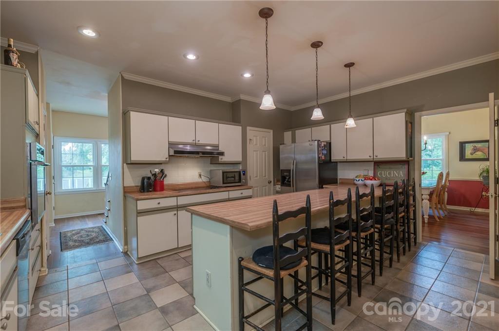4733 Hunting Country Road Tryon, NC 28782 - Photo 15 of 48 a kitchen with stainless steel appliances kitchen island granite countertop a table chairs and a refrigerator