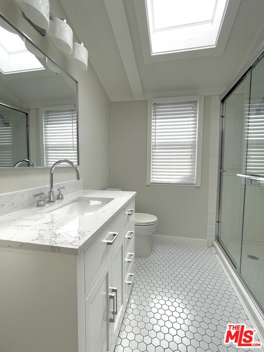 29500 Heathercliff Road, Unit 260 Malibu, CA 90265 - Photo 14 of 23 a bathroom with a granite countertop sink a toilet and a window