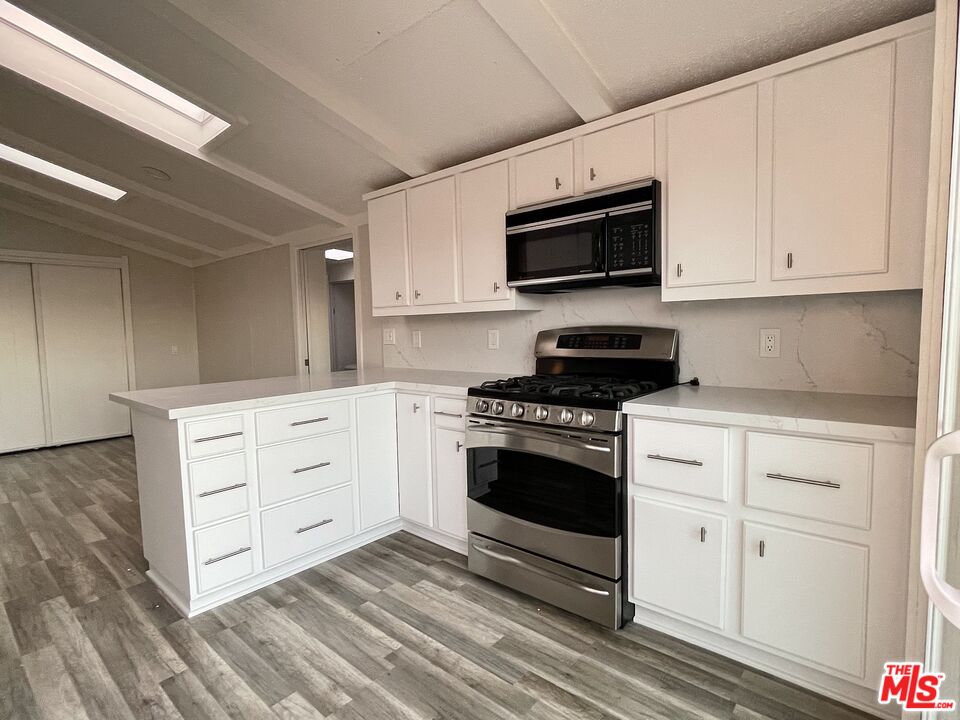 29500 Heathercliff Road, Unit 260 Malibu, CA 90265 - Photo 7 of 23 a kitchen with stainless steel appliances white cabinets and a stove a oven with white countertops