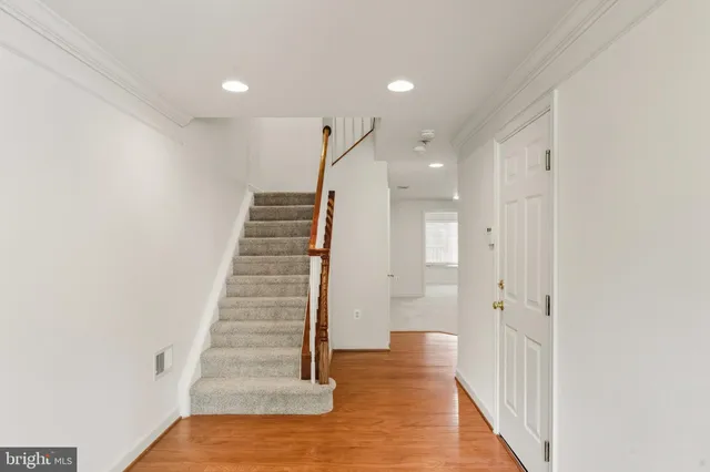 a view of a hallway with wooden floor and a dining room