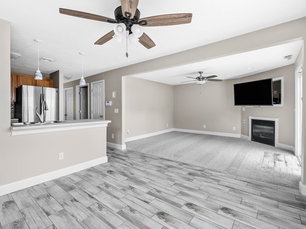 20 Angela Rose Lane Worcester, MA 01604 - Photo 18 of 35 a view of a livingroom with a flat screen tv ceiling fan and hardwood floor