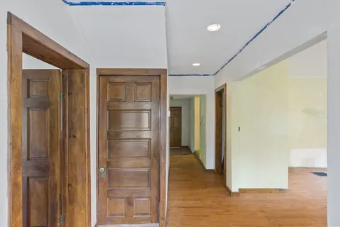 a view of a livingroom with a fireplace a chandelier and wooden floor