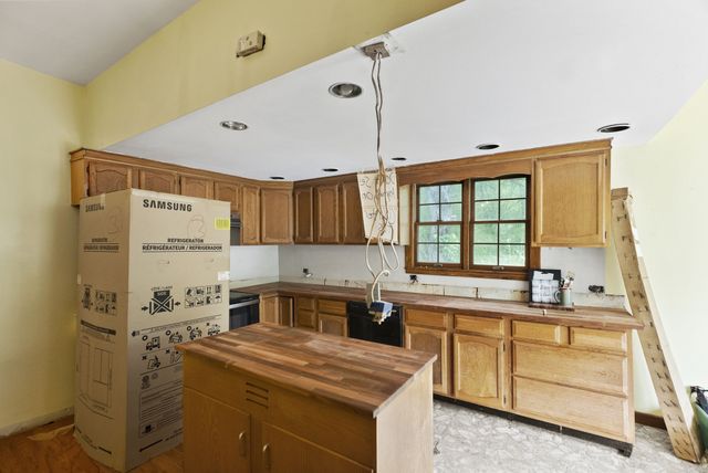 a kitchen with kitchen island a stove a sink and a refrigerator
