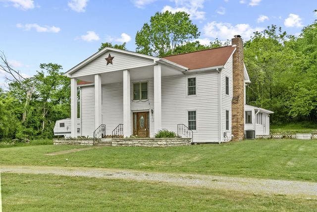 a front view of house with yard and green space