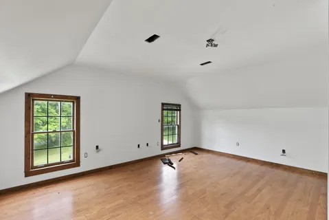 a view of room with walk in closet and wooden floor