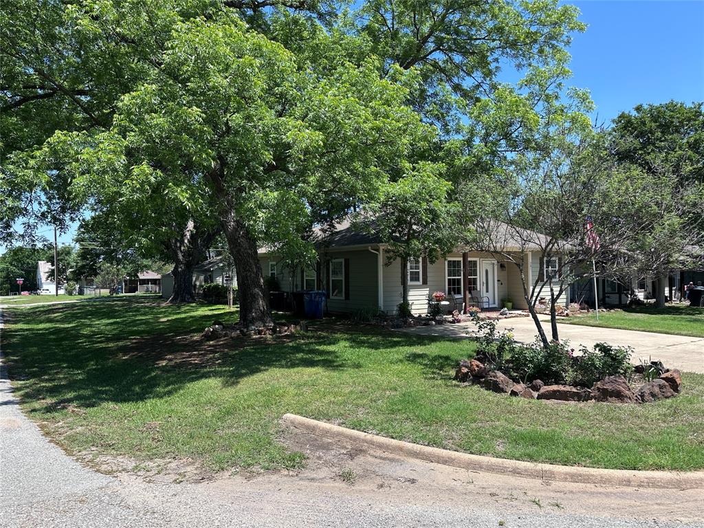 201 East Walker Street Denison, TX 75021 - Photo 2 of 19 a front view of a house with a garden and trees