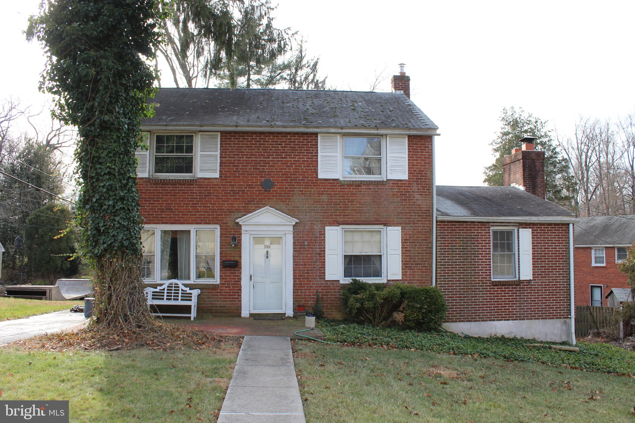 a front view of a house with a yard and trees