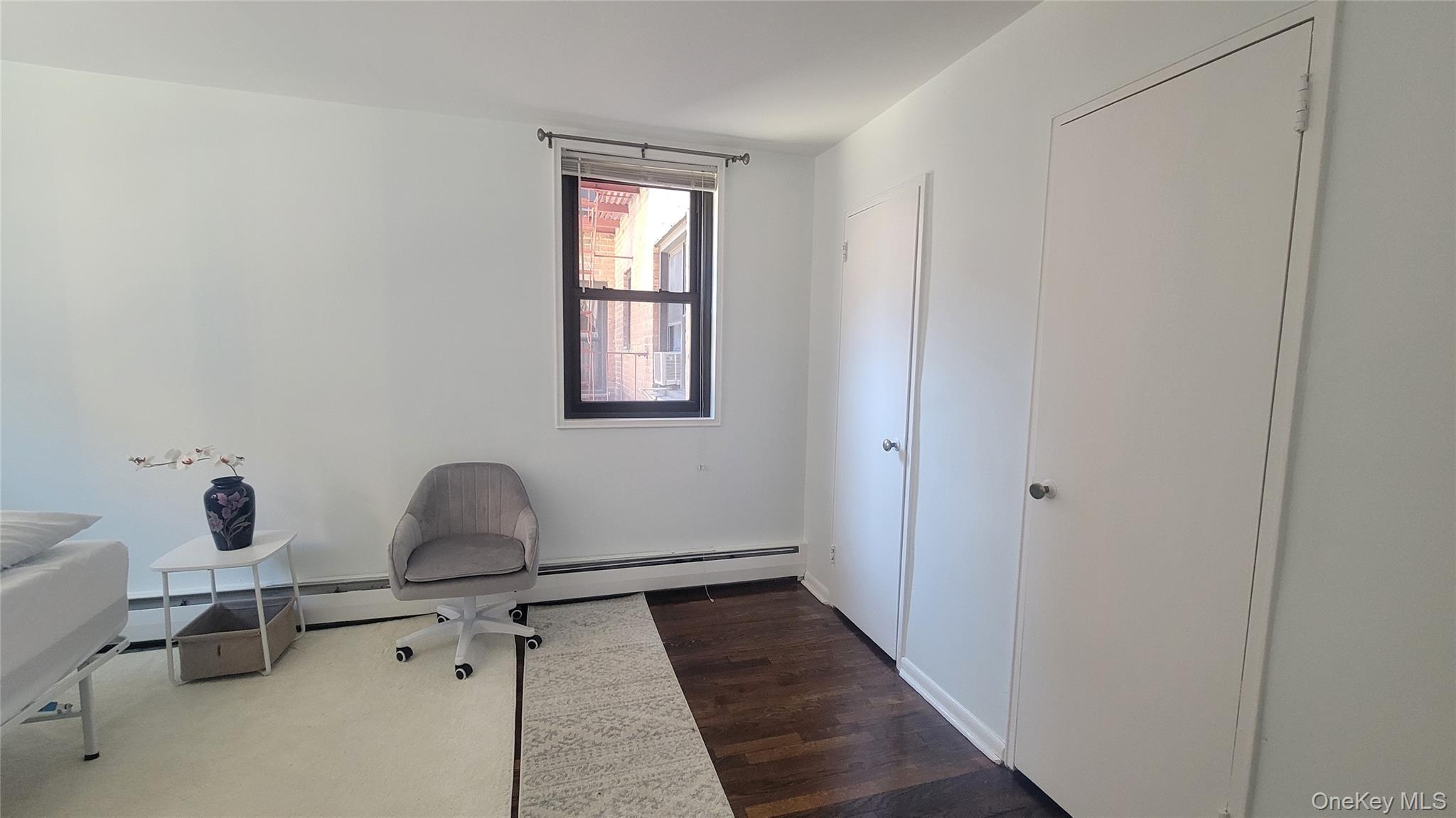 99-06 58th Avenue, Unit 2F Queens, NY 11368 - Photo 11 of 24 a room with table chair and windows