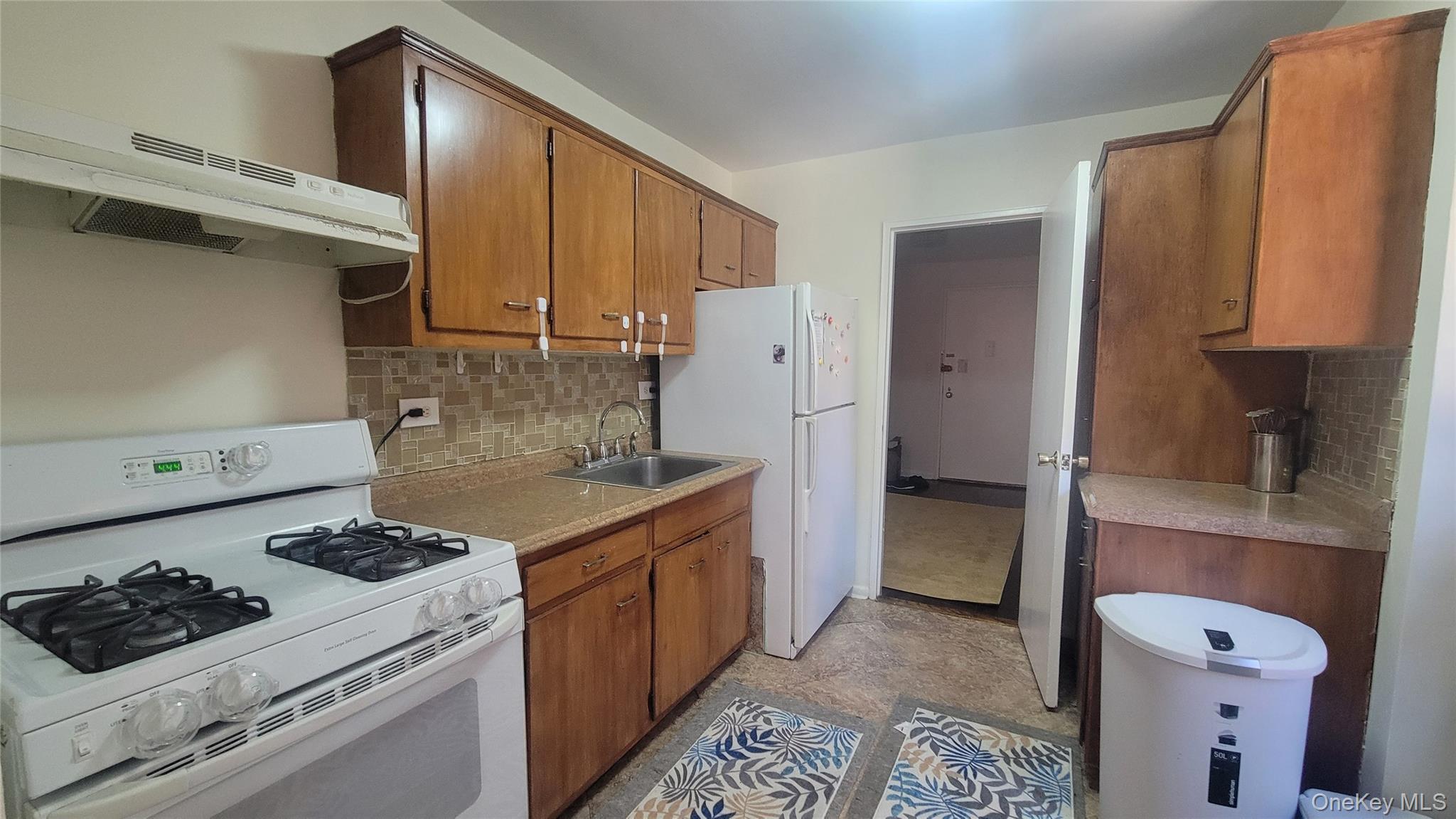 99-06 58th Avenue, Unit 2F Queens, NY 11368 - Photo 15 of 24 a kitchen with stainless steel appliances granite countertop a sink stove and refrigerator