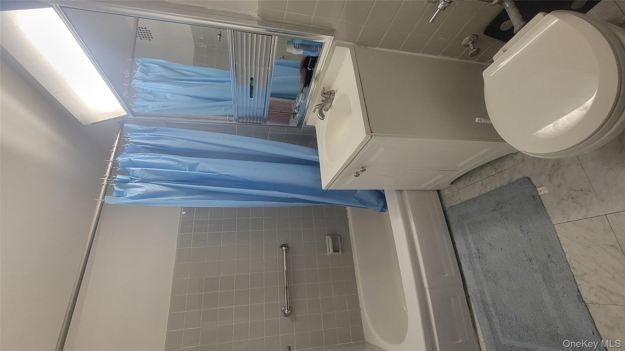 99-06 58th Avenue, Unit 2F Queens, NY 11368 - Photo 19 of 24 a bathroom with a sink a toilet and bathtub