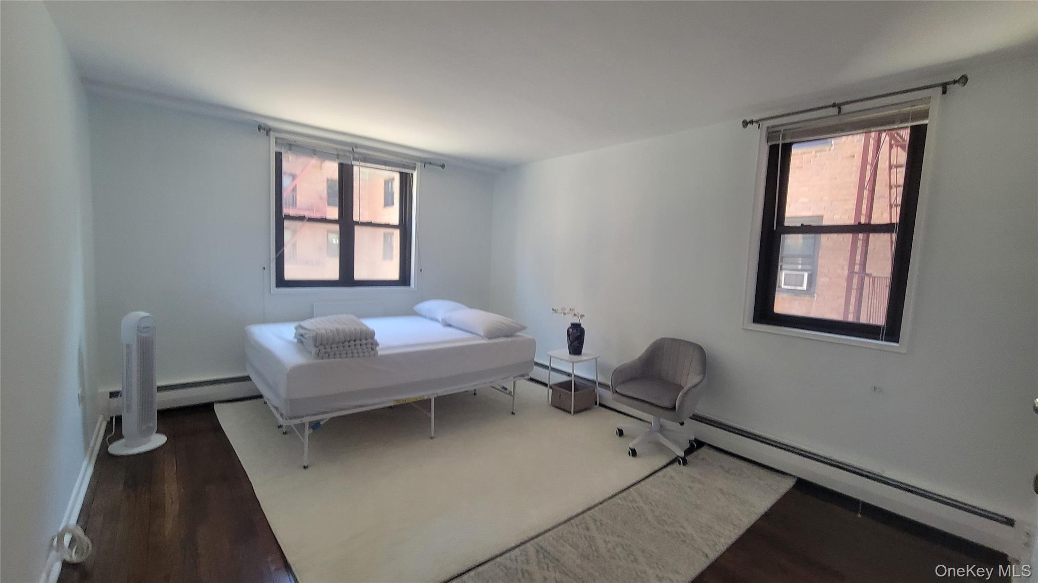99-06 58th Avenue, Unit 2F Queens, NY 11368 - Photo 9 of 24 a living room with furniture and a window