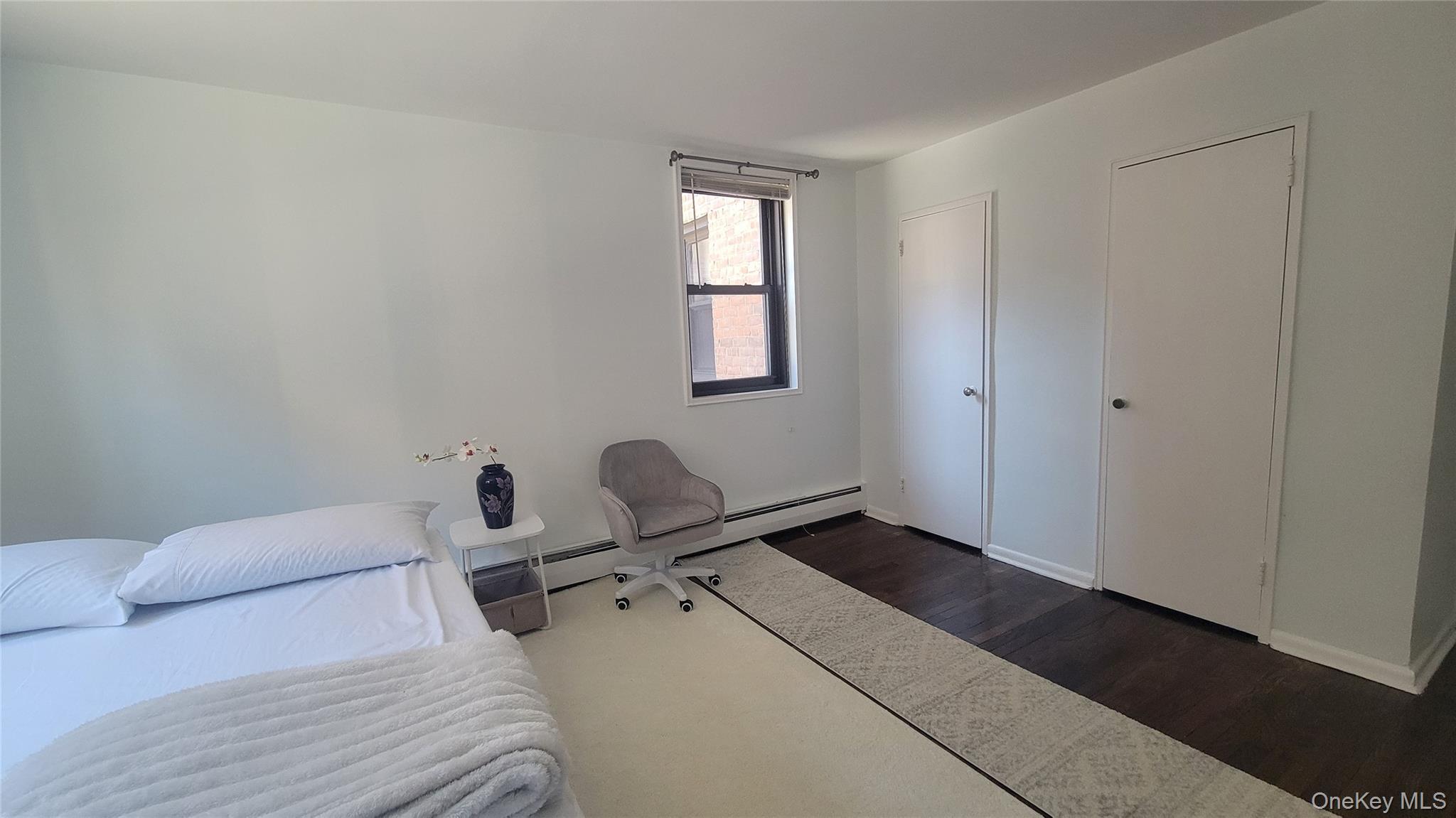 99-06 58th Avenue, Unit 2F Queens, NY 11368 - Photo 10 of 24 a room with a bed and a window