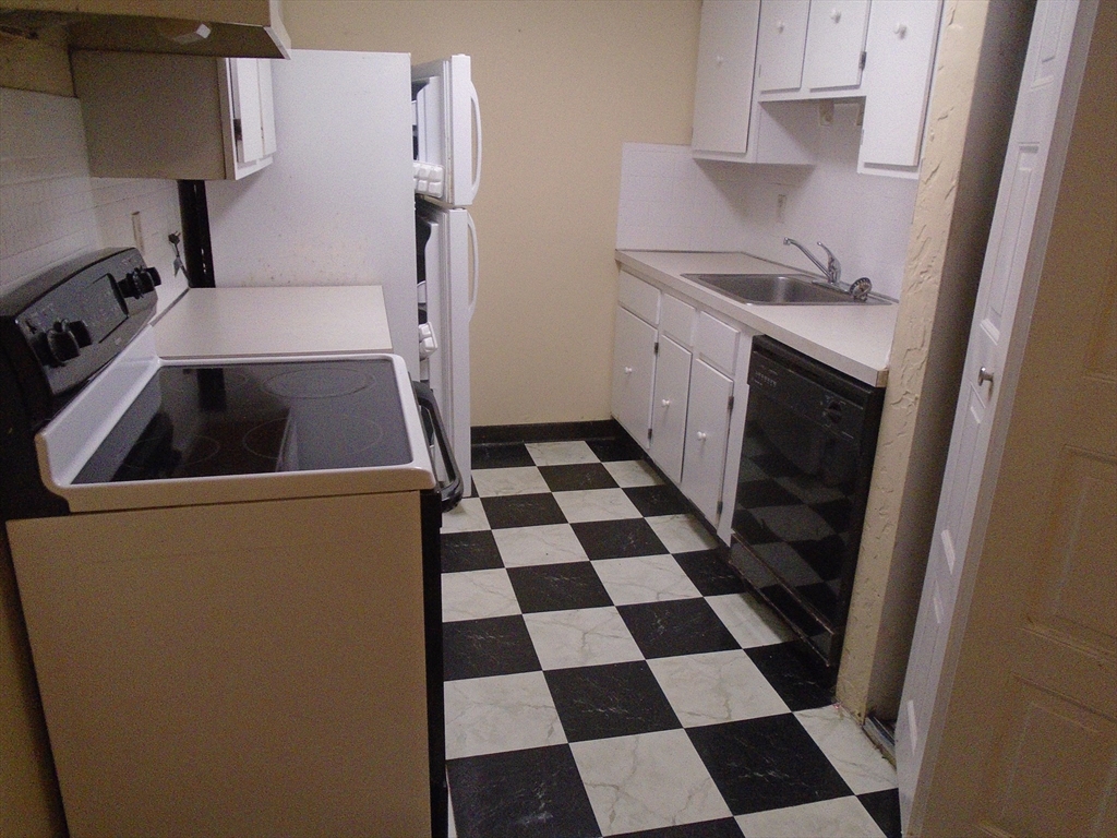 451 School Street, Unit 34 Marshfield, MA 02050 - Photo 6 of 18 a kitchen with a refrigerator a sink and cabinets