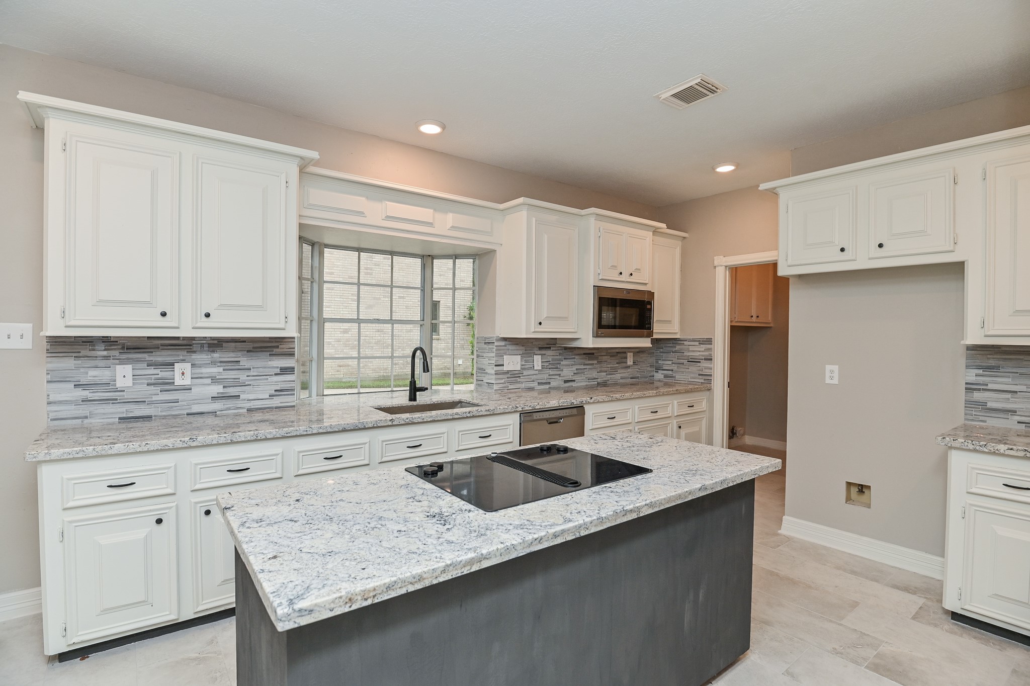 17910 Moss Point Drive Spring, TX 77379 - Photo 12 of 32 a kitchen with granite countertop white cabinets and white appliances