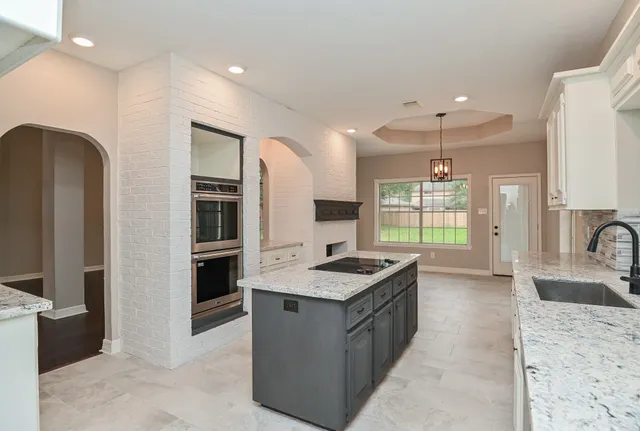 a kitchen with granite countertop white cabinets and white appliances
