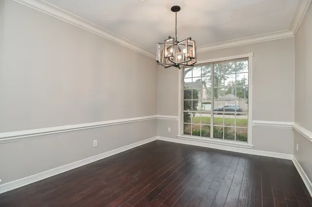 a view of a livingroom with a chandelier wooden floor and chandelier
