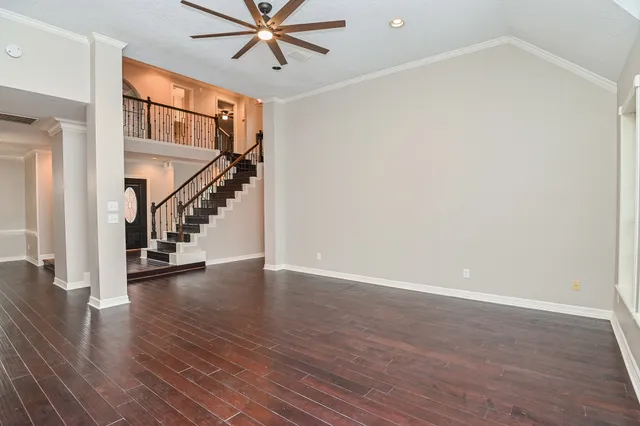 a view of an empty room with wooden floor fireplace and a window