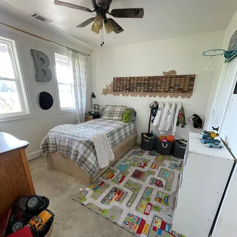 a bedroom with a bed a couch and a window