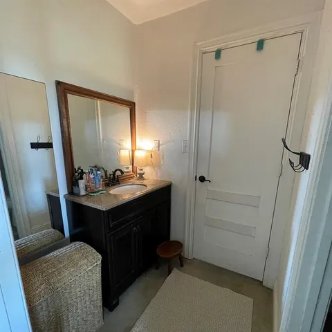 a bathroom with a sink vanity granite tub and shower