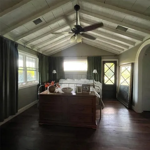 a bed sitting in a spacious bedroom next to a window