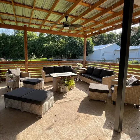 a view of a patio with couches chairs and a large umbrella