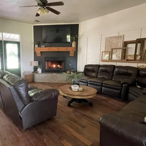 a living room with furniture a fireplace and a flat screen tv
