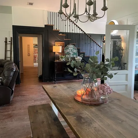 a living room with furniture flowerpot and a chandelier