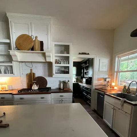 a kitchen with stainless steel appliances a sink a stove and cabinets
