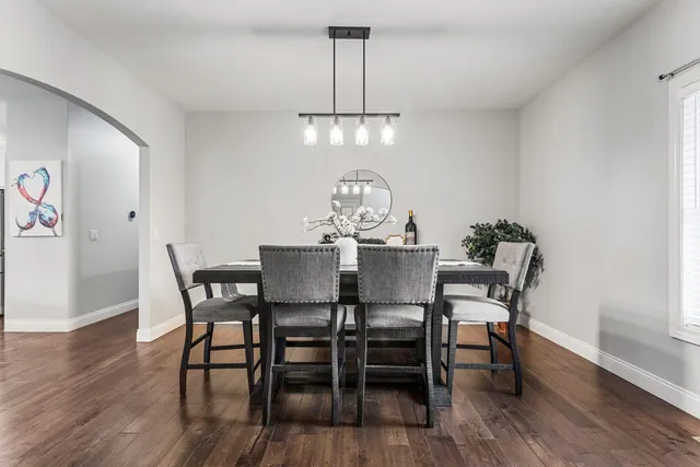 a view of a dining room with furniture a chandelier and wooden floor