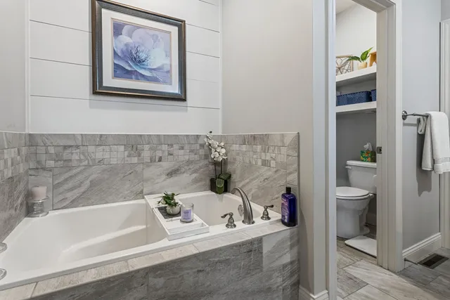 a hallway with white cabinets and wooden floor