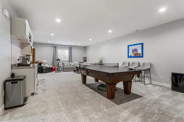 a room with furniture pool table and window