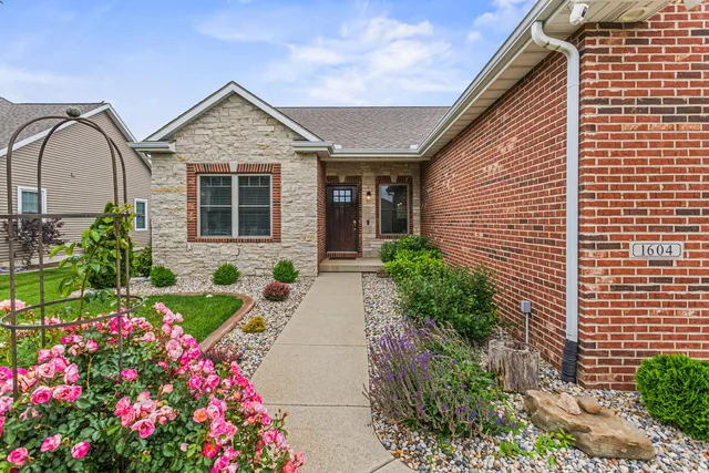 a front view of a house with lots of flowers in it