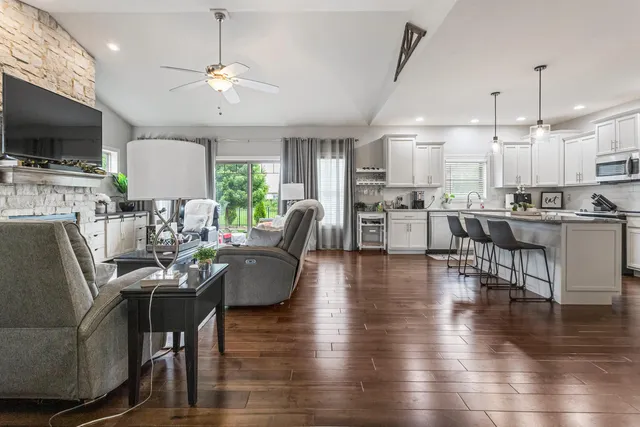 a living room with stainless steel appliances furniture and a flat screen tv