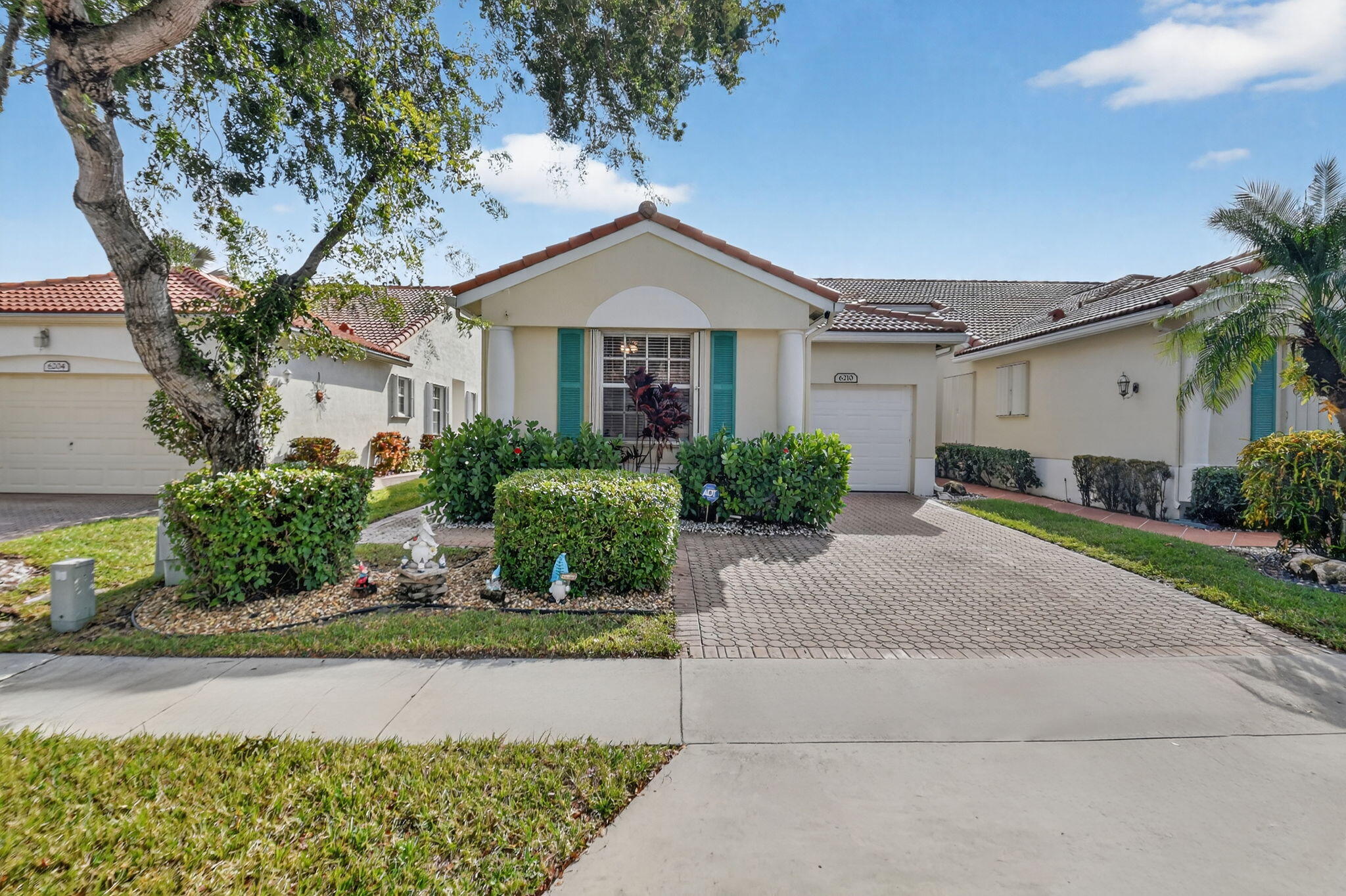 6210 Heliconia Road Delray Beach, FL 33484 - Photo 2 of 53 a front view of a house with a yard and garage