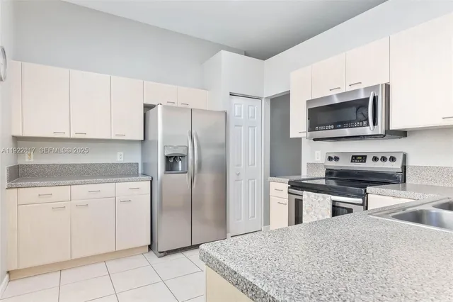 a kitchen with cabinets stainless steel appliances and a counter space