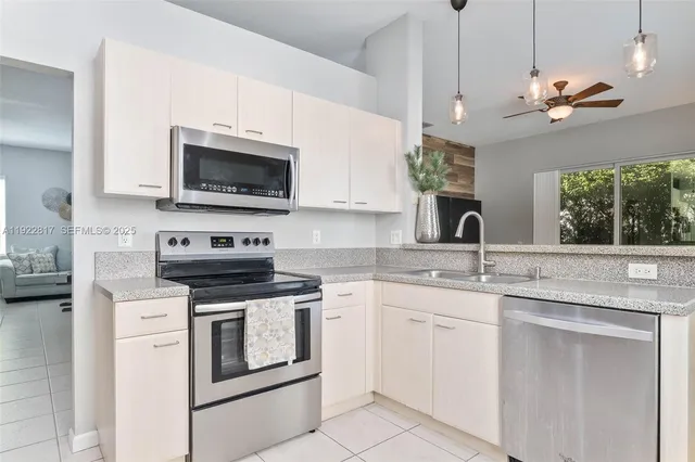 a kitchen with white cabinets and appliances