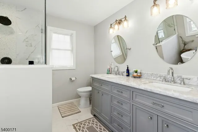 a bathroom with a granite countertop toilet sink and mirror