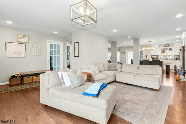 a living room with furniture and a dining table with wooden floor