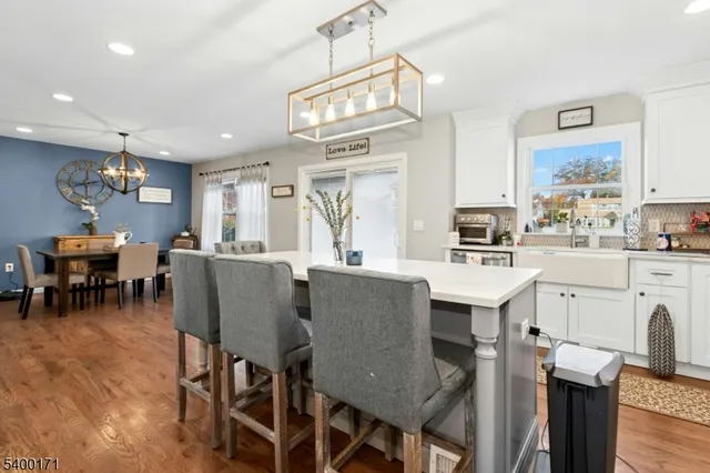 a living room with stainless steel appliances kitchen island granite countertop furniture and a large window