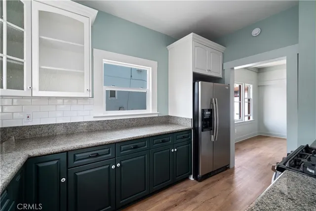 a kitchen with stainless steel appliances granite countertop a refrigerator and a sink