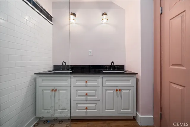 a bathroom with a granite countertop sink and a mirror