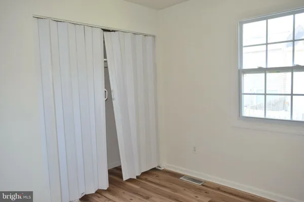 a view of a closet area with hardwood floor