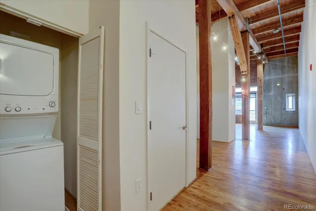 a view of a hallway with wooden floor and a bathroom