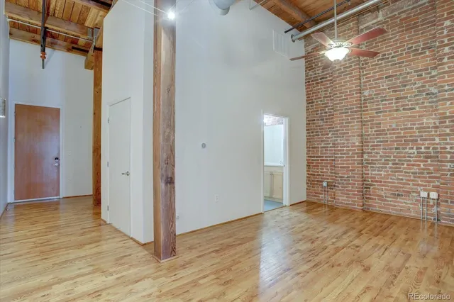 a view of a room with wooden floor and brick walls