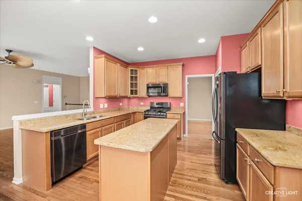 a kitchen with kitchen island a sink stove and refrigerator